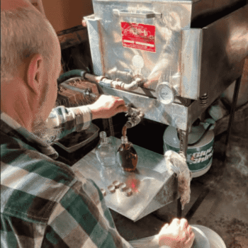 Pouring Witt's Maple Syrup into bottles.